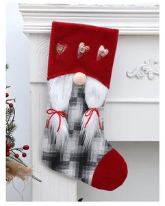 Vista detallada de calcetín navideño con diseño de gnomo en una chimenea blanca
