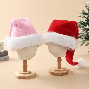 Two plush long-hair Christmas hats in red and pink displayed on wooden head stands