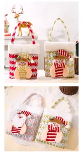 Close-up view of festive Christmas gift bags with 3D plush snowman and Santa motifs.