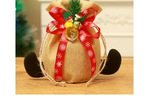 Detailopname van een kerstcadeauzakje van jute met rood sneeuwvloklint en belletjes.