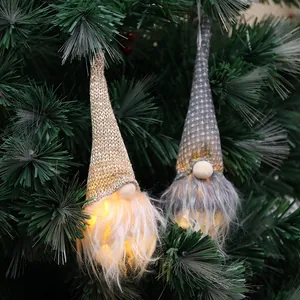 Decorative illuminated Christmas gnome ornaments with warm LED lights hanging on a tree