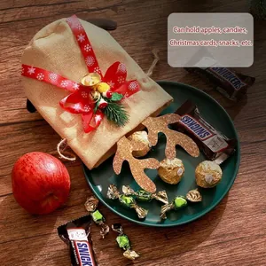Feestelijke kerstzak van jute met rendiergewei en rode strik voor snoepgoed en appels