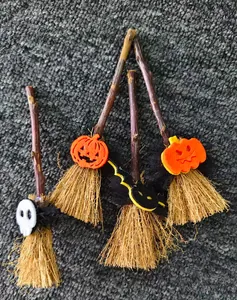 Primer plano de cuatro mini escobas de bruja de Halloween con calabaza, calavera y murciélago