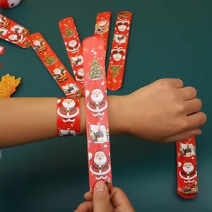 Detail von Weihnachts-Schnapparmbändern mit Weihnachtsmann am Handgelenk eines Kindes
