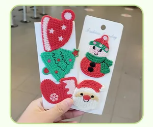 Vue détaillée des barrettes à cheveux brodées de Noël sur carte blanche.