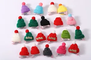 Detailansicht bunter Mini-Strickmützen-Haarspangen mit LOVE-Patch und flauschigen Bommeln