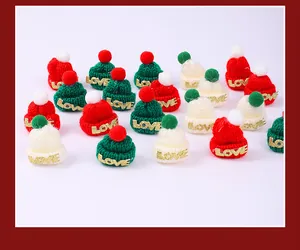 Detailed view of mini Christmas knitted hats in red green and white with gold LOVE decoration