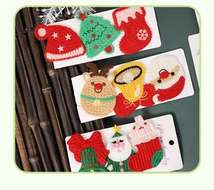 Gros plan de diverses pinces à cheveux de Noël brodées aux motifs festifs variés.