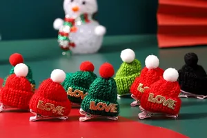 Detailansicht von Mini-Weihnachtsstrickmützen-Haarspangen mit goldenen LOVE-Buchstaben