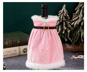 Detailed view of pink velvet wine bottle dress with white fur trim on a festive table.