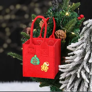 Rode vilten kerstcadeautas met feestelijke patches aan een versierde kerstboom
