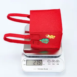 Detailweergave van een lichtgewicht rode kerst vilten geschenktas van 27,5 gram op een weegschaal