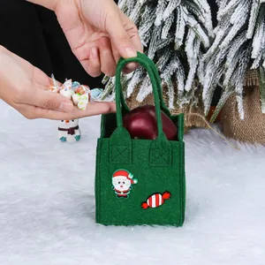 Groene vilten kerstcadeauzak voor appels en snoepjes met een vrolijk kerstmanontwerp