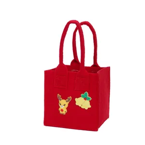 Rode vilten kerstcadeautas met rendier- en klokdecoraties op een witte achtergrond