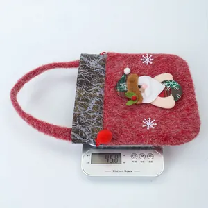 Rote flauschige Weihnachts-Geschenktüte mit Weihnachtsmann-Applikation auf einer Küchenwaage