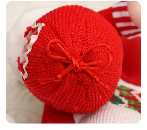 Makroaufnahme eines roten gestrickten Weihnachts-Apfelbeutels mit Schleife.