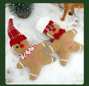 Macro view of soft corduroy gingerbread man plush ornaments in a festive snow scene.