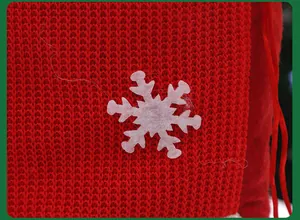 Detailaufnahme der roten gestrickten Weihnachtsgeschenktüte mit weißer Schneeflocke