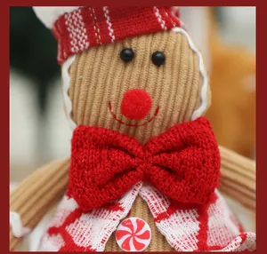 Macro view of gingerbread man plush doll detail with red knitted bow tie and candy button