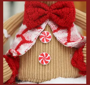 Detailed view of a Christmas gingerbread man doll with red knitted bow
