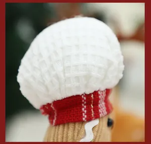Close-up detail of a Christmas gingerbread man plush doll with a white waffle knit chef hat