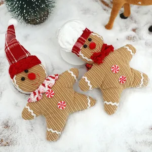 Pair of corduroy gingerbread man plush dolls Christmas tree ornaments on artificial snow