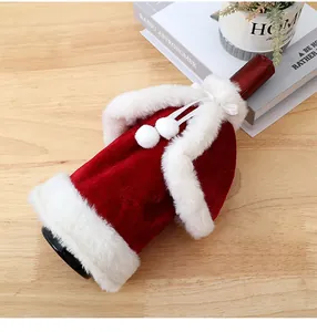 Close-up of red velvet Christmas wine bottle cover with white fur trim