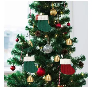 Gros plan de mini chaussettes de Noël tricotées suspendues en ornements sur un sapin.