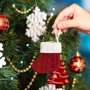 Red and white knitted mini Christmas stocking ornament hanging on a festive tree
