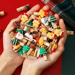 Assorted Christmas wooden clips with cute cartoon charms for DIY crafts.