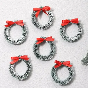 Set van zes mini sneeuw-kerstkransen met rode strikken voor sfeervolle kerstversiering.