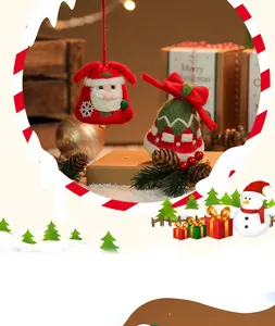 Gedetailleerde weergave van handgemaakte kerstklokjes van wolvilt met kerstmandesign.