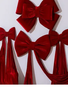 Detailed macro view of large red velvet Christmas bows hanging for festive decoration.