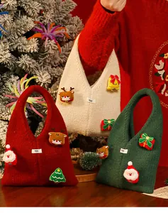Drei festliche gestrickte Weihnachts-Geschenktüten in Rot, Grün und Beige mit 3D-Anhängern.