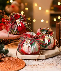 Detailansicht festlicher Plüsch-Geschenkbeutel mit Karo-Muster und Anhängern.