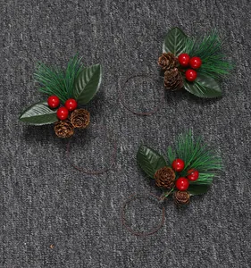 Detalle de servilleteros navideños hechos a mano con agujas de pino, bayas y piñas