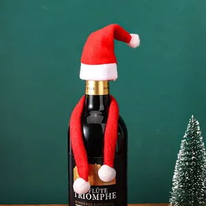 Festive red Santa hat and scarf set decorating a wine bottle for Christmas celebrations.