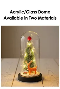 Close-up detail of a mini glowing Christmas tree inside a glass dome with reindeer