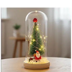 Vista detallada de mini árbol de Navidad luminoso en cúpula de cristal con Papá Noel