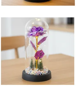 Vista detallada de rosa artificial morada en cúpula de cristal con luces LED cálidas