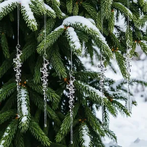 Décorations de Noël en stalactites d'acrylique transparent sur une branche de sapin.