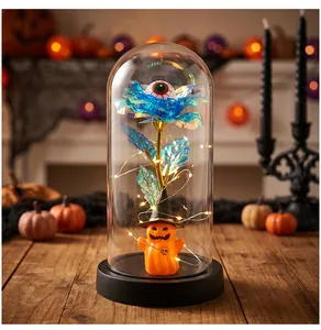 Vista detallada de la cúpula de cristal de Halloween con rosa azul, ojo y calabaza brillante