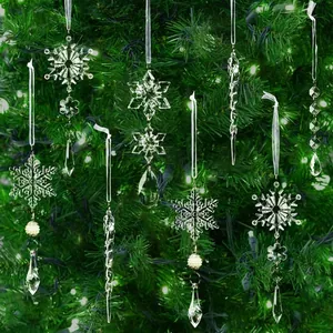 Detalle de adornos de copos de nieve y carámbanos de acrílico colgados en un árbol de Navidad.