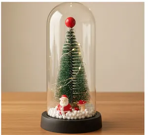 Vista detallada de un mini árbol de Navidad en cúpula de vidrio con figura de Papá Noel