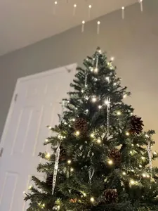 Decorazioni in acrilico trasparente a forma di ghiacciolo su un albero di Natale luminoso.