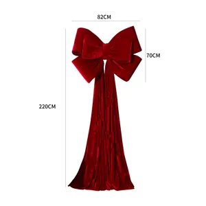 Large red velvet Christmas bow decoration with 220cm long streamers for festive scenes.