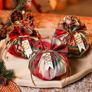 Festive karierte Weihnachtsgeschenkbeutel auf Dekotablett mit Anhängern