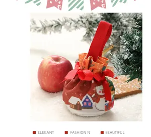 Primo piano di un sacchetto regalo di Natale con pupazzo di neve e nastro di raso rosso.