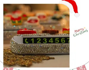 Close-up of rhinestone Christmas car parking phone number plate with cute Santa decor.