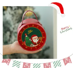 Runde rote Weihnachtsgeschenkbox mit Weihnachtsmann und Baum, in der Hand gehalten